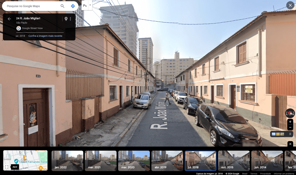 Rua em uma vila operária com casas geminadas dos dois lados.