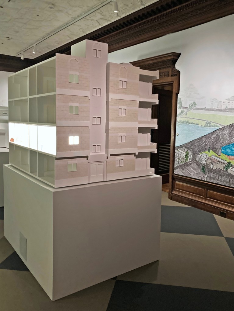 Maquete de uma edificação residencial de três pavimentos com destaque para um apartamento.