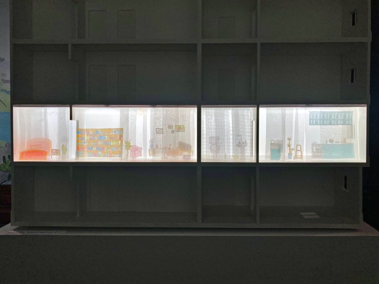 Maquete de uma edificação residencial de três pavimentos com destaque para um apartamento.