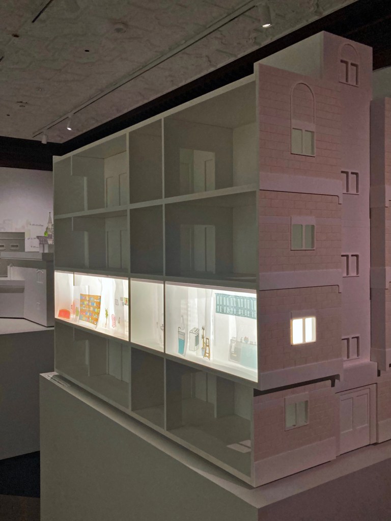 Maquete de uma edificação residencial de três pavimentos com destaque para um apartamento.