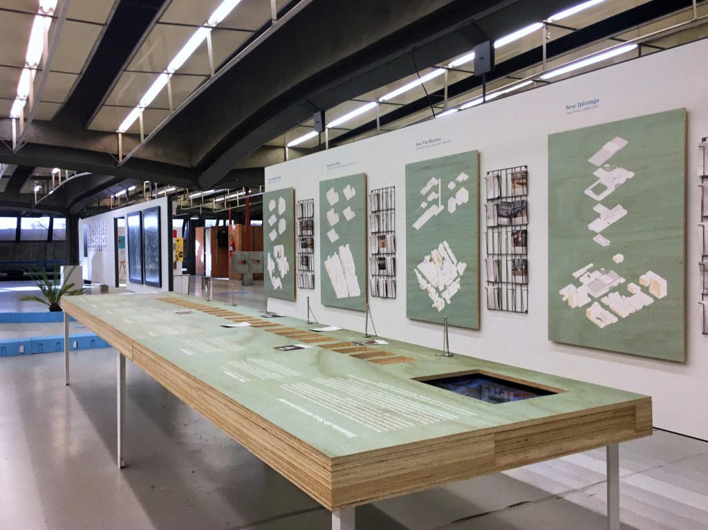 Aspecto da Bienal de Arquitetura com painéis e mesas expositivas